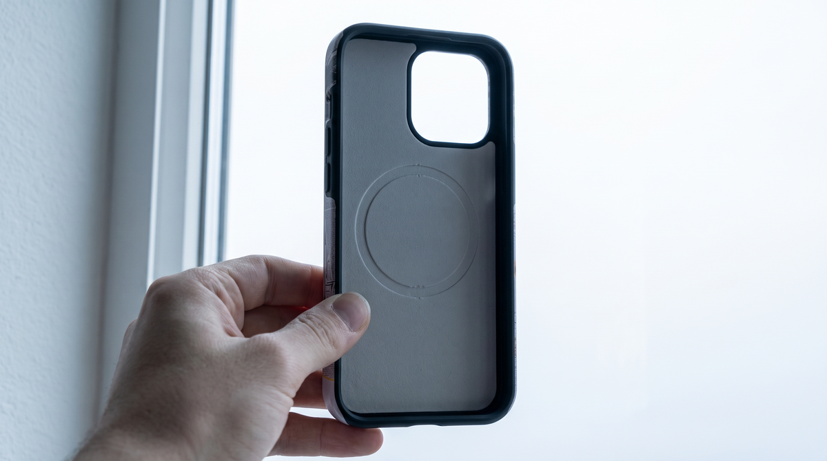 Arabesque Saint iPhone tough case held to the light showing the circular magnet array seam inside the shell